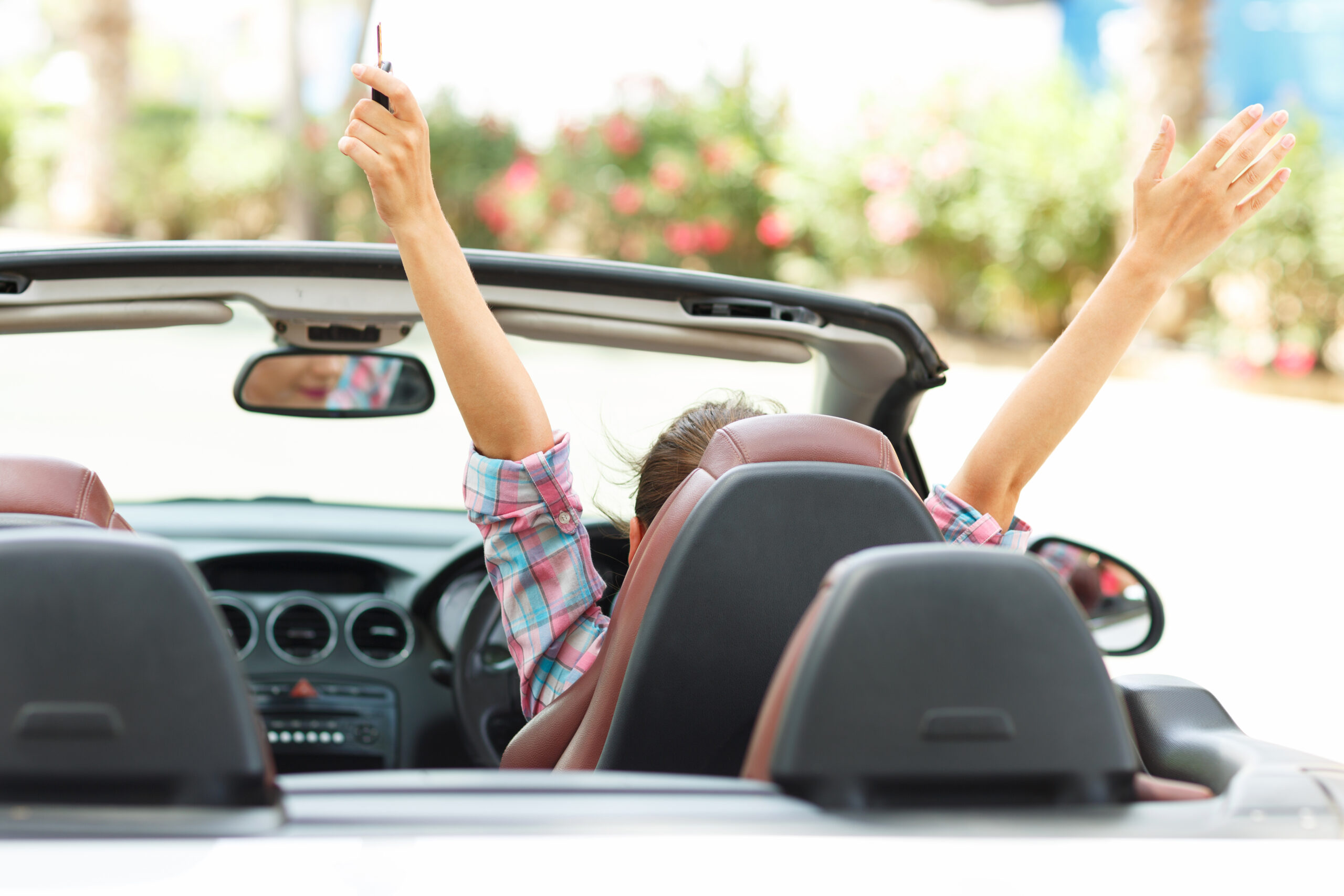 Freedom – happy free woman in cabriolet cheering joyful with arm