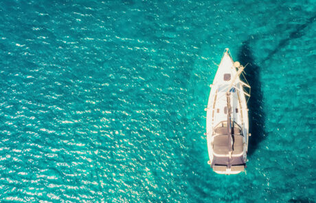 Boat sail floats near the shore. Luxury Lifestyle. Travel on sailboat at sea with clear water. Calm place